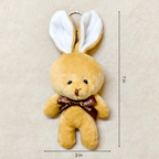 Plush bunny toy with a brown bow and measurement details on a beige background