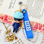 Keychain with character figure and 'HERO' tag on a textured surface