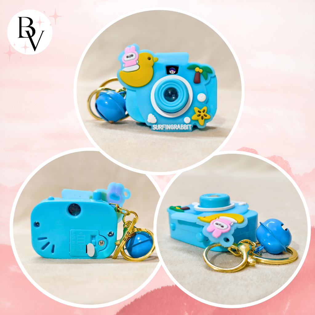 Blue toy camera with keychain on a pink and beige background
