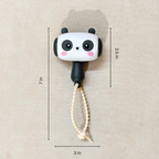 Panda-shaped toy with measurements on a beige background