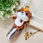 Plush squirrel toy on a surface with an open book and decorative elements.