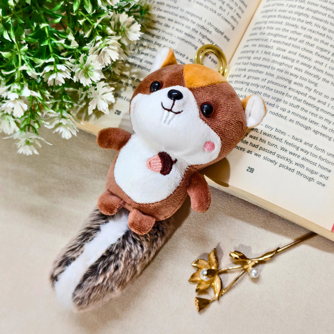 Plush squirrel toy on a surface with an open book and decorative elements.