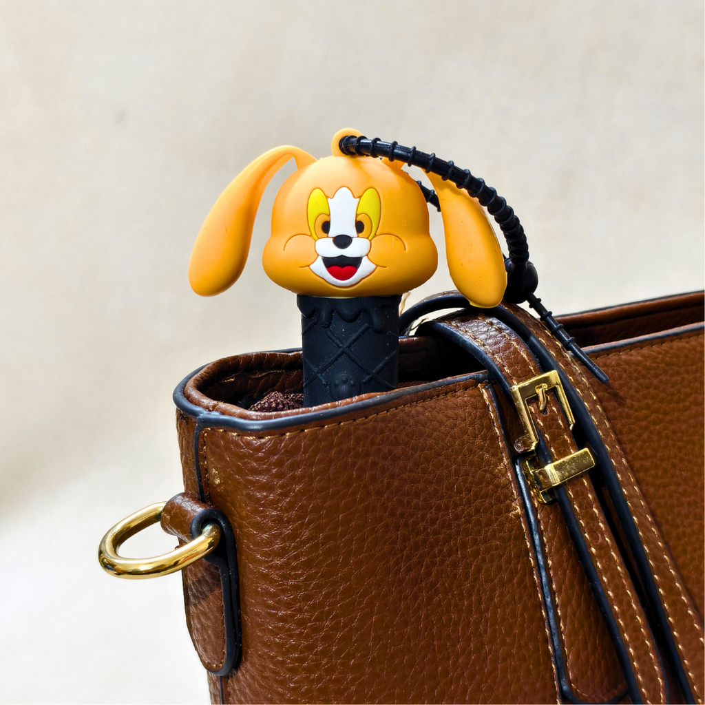 Cartoon dog-shaped phone case peeking out of a brown leather bag