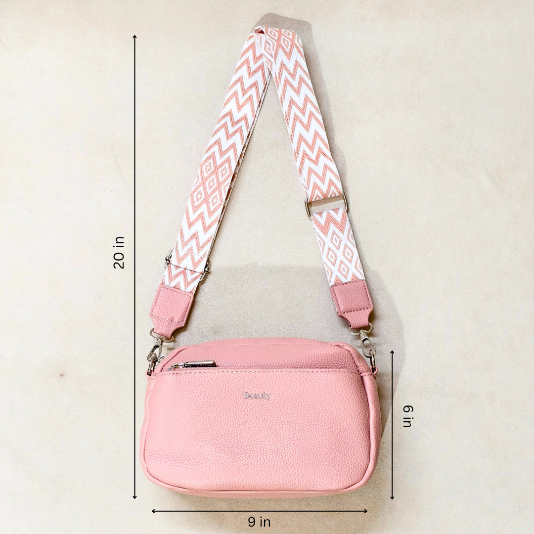 Pink pebbled faux-leather crossbody bag with a wide pink-and-white chevron patterned strap, shown with dimension lines indicating 20 in height, 9 in width, and 6 in depth on a light beige background.