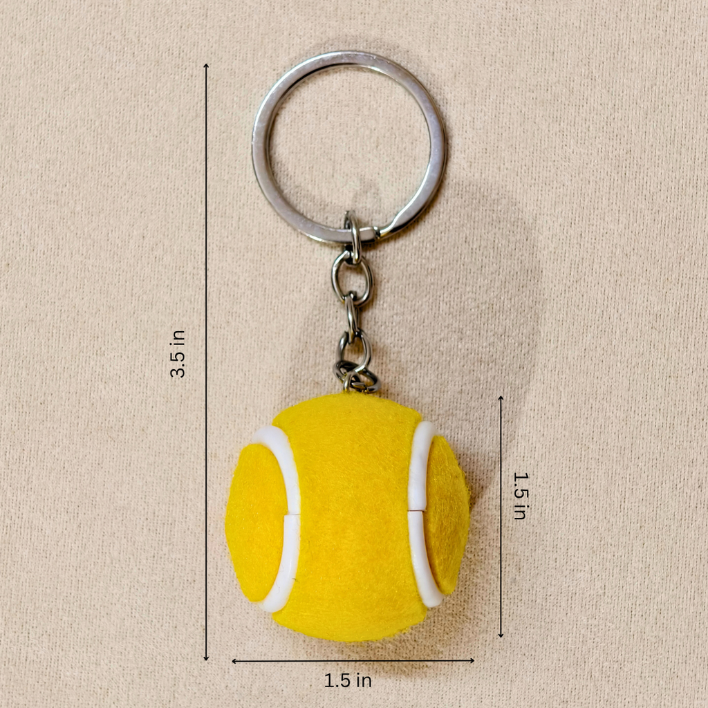 A yellow felt tennis ball keychain with a silver metal split ring and chain, shown on a beige textured background with dimension lines indicating measurements of 1.5 inches in diameter and 3.