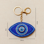Blue eye-shaped keychain with measurements on a beige background