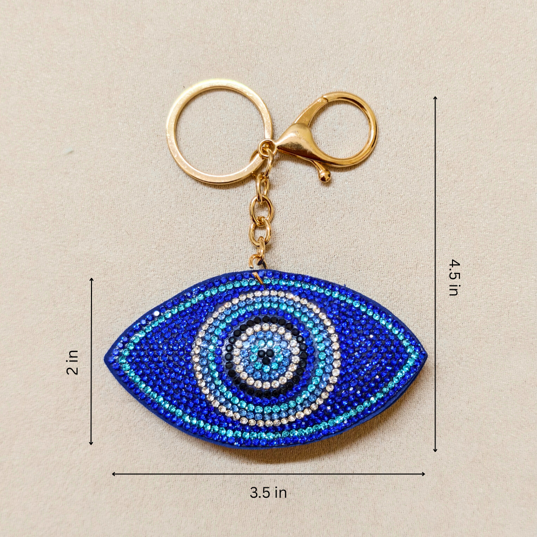 Blue eye-shaped keychain with measurements on a beige background