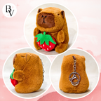 Plush bear toy with a strawberry and keychain on a pink background