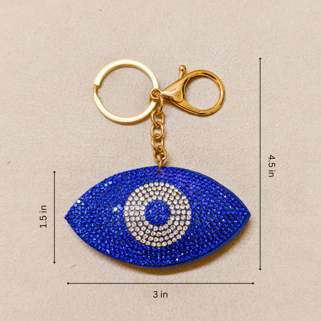 Blue eye-shaped keychain with gold clasp on beige background