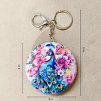 Keychain with peacock and floral design, shown with measurements on a beige background