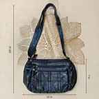 Black leather handbag with measurements on a beige background