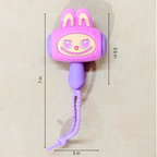 A pink and purple cartoon rabbit-shaped wall hook with a dangling cord, shown on a beige background with dimension lines indicating 7 in height, 3.5 in width, and 3 in cord span.