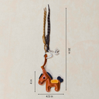 Brown horse-shaped keychain with long antlers on a beige background with measurements.