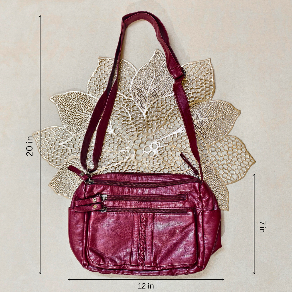 Maroon handbag with measurements on a beige background