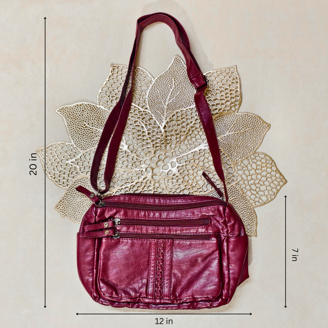Maroon handbag with measurements on a beige background