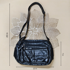 Black handbag with measurements on a beige background