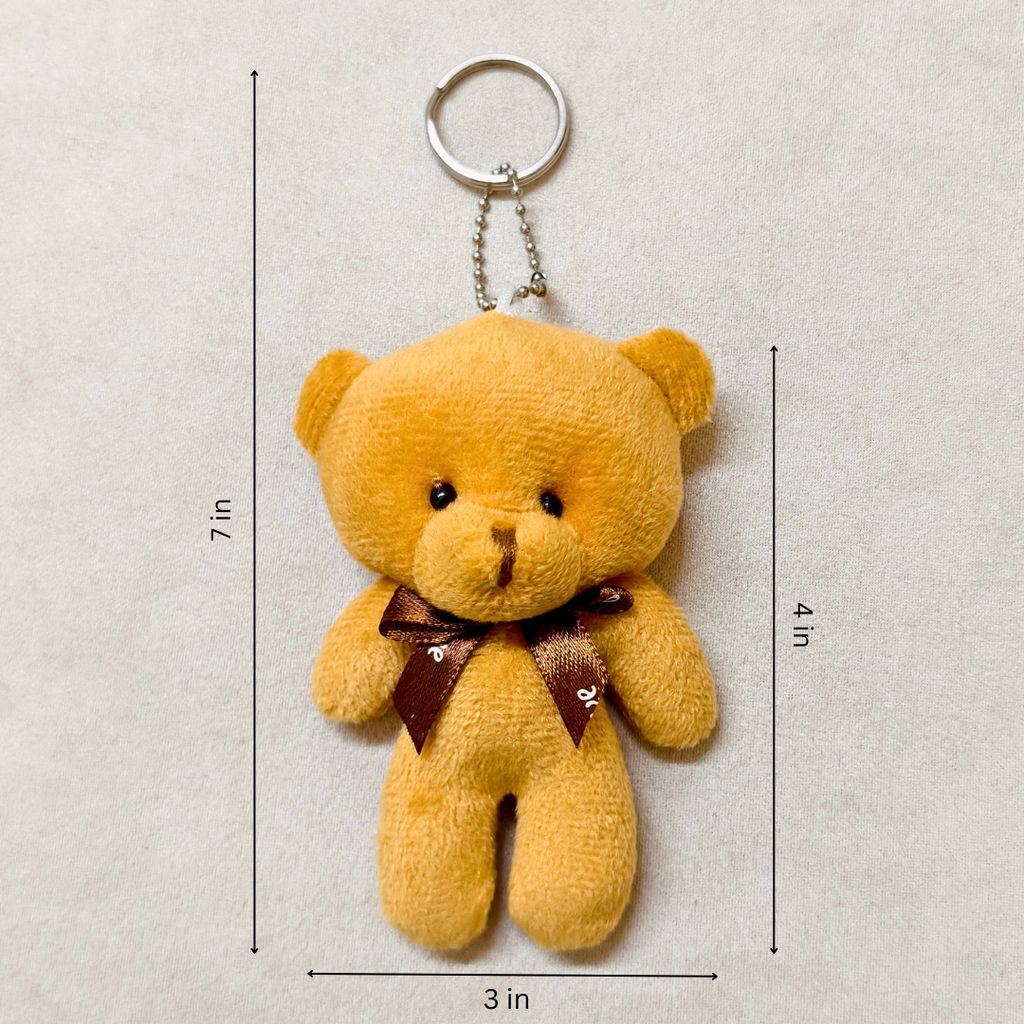 Yellow teddy bear keychain with dimensions on a beige background
