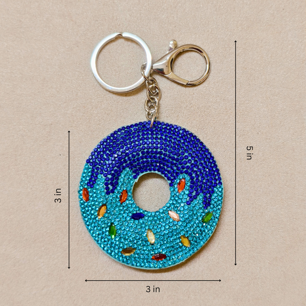 Blue donut-shaped keychain with colorful sprinkles on a beige background with measurements.