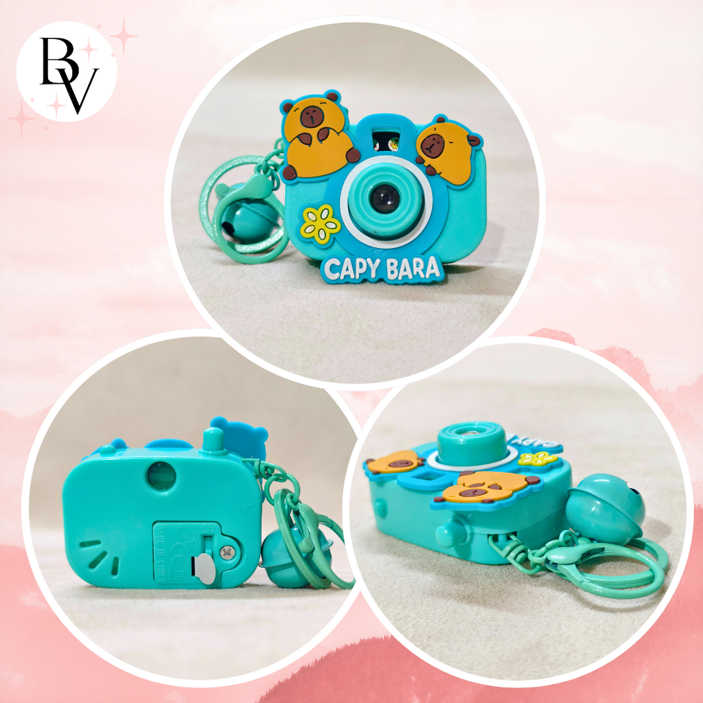 Turquoise toy camera with animal-themed design on a pink background