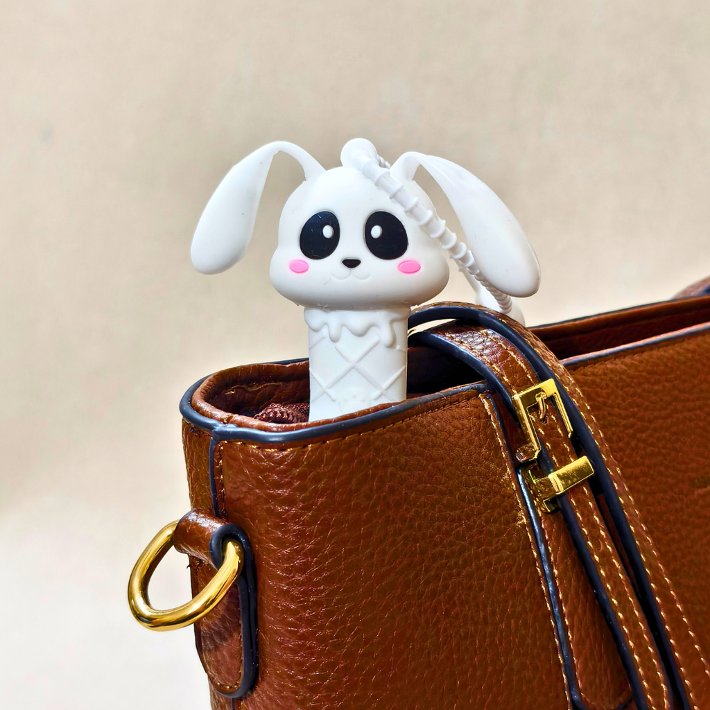 White rabbit-shaped earphone holder in a brown leather bag