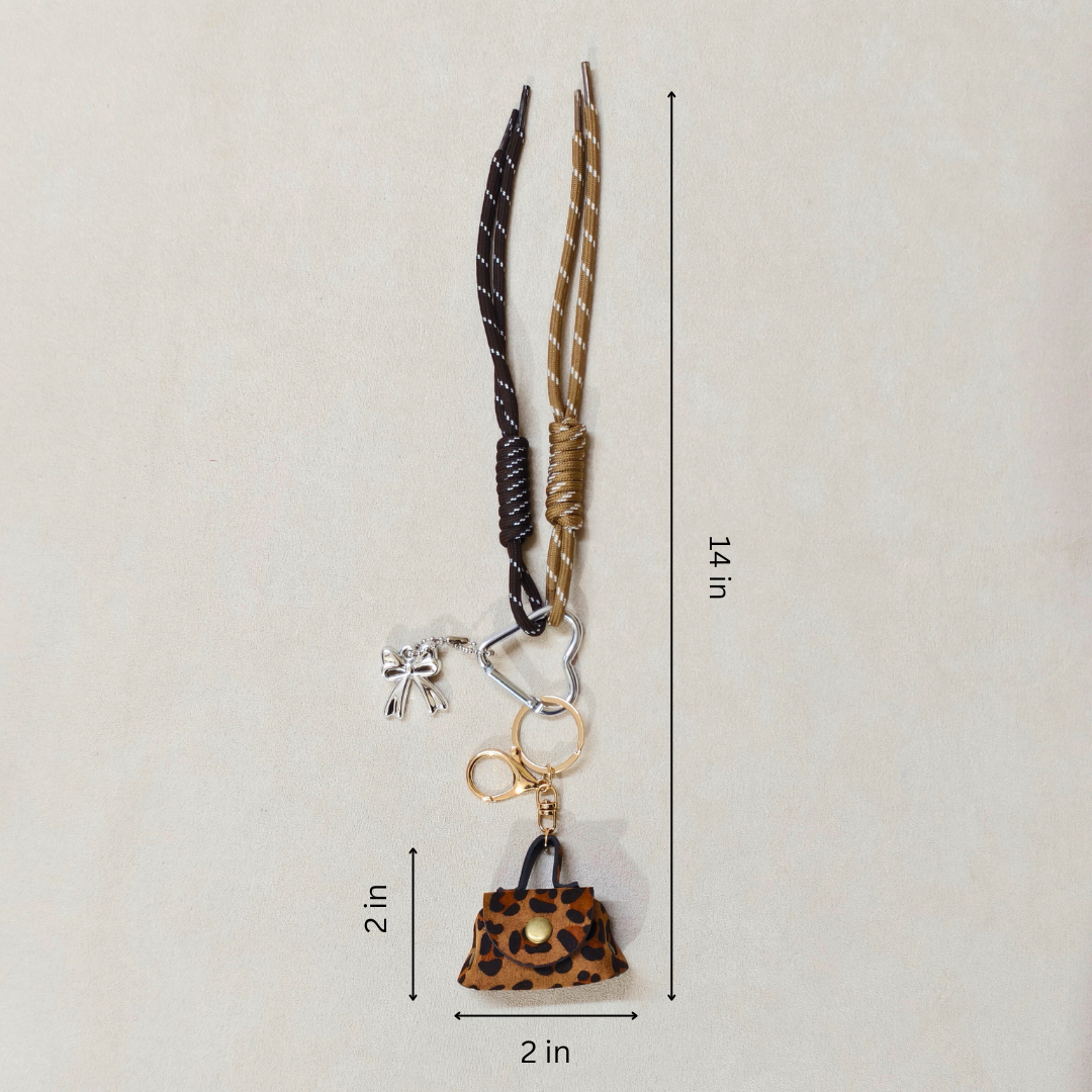 Keychain with leopard print purse charm and measurement details on a beige background