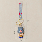 Keychain with character figure and measurement details on a beige background