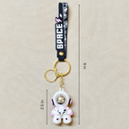 Small Astronaut Keyring With Measurements  On Beige Background.