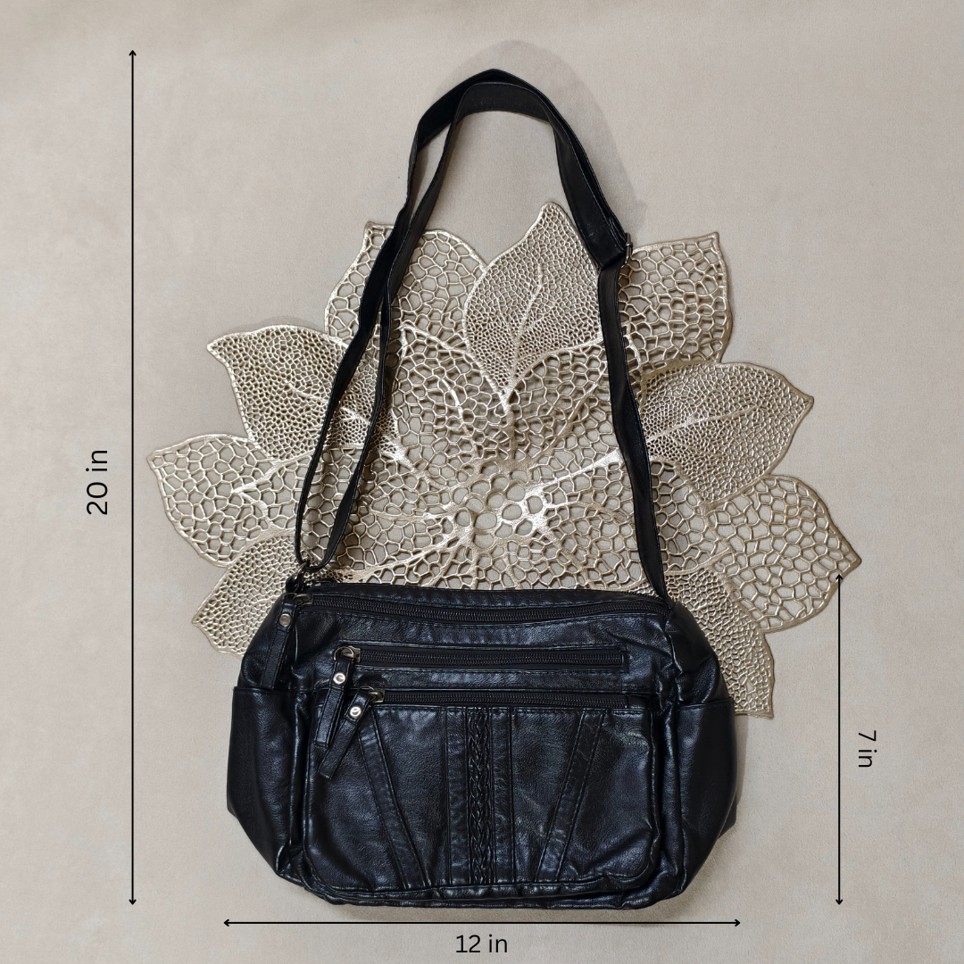 Black leather handbag with measurements on a textured beige background