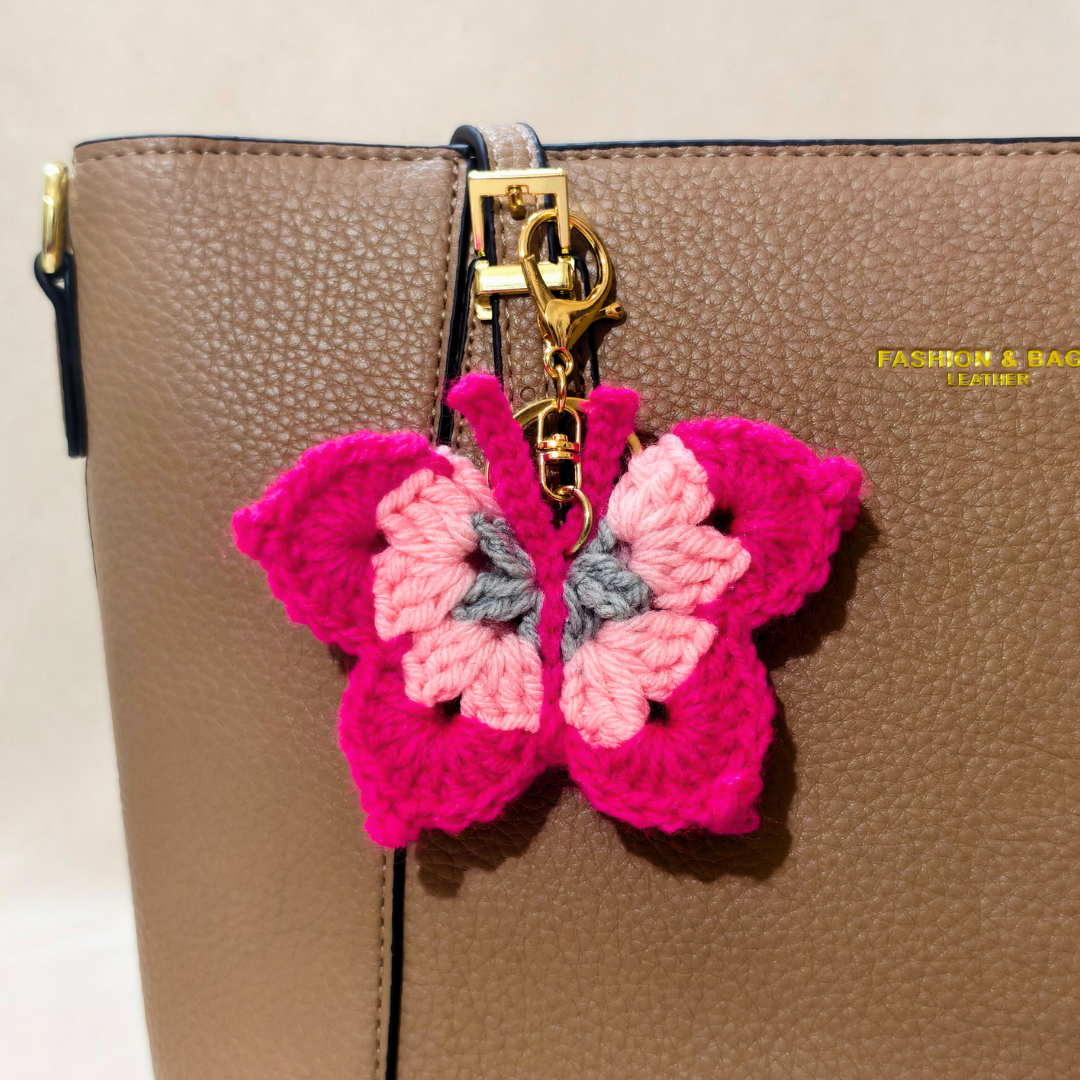 Pink butterfly keychain attached to a brown bag