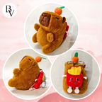 Plush toy bear with a red heart and orange carrot, on a pink background.