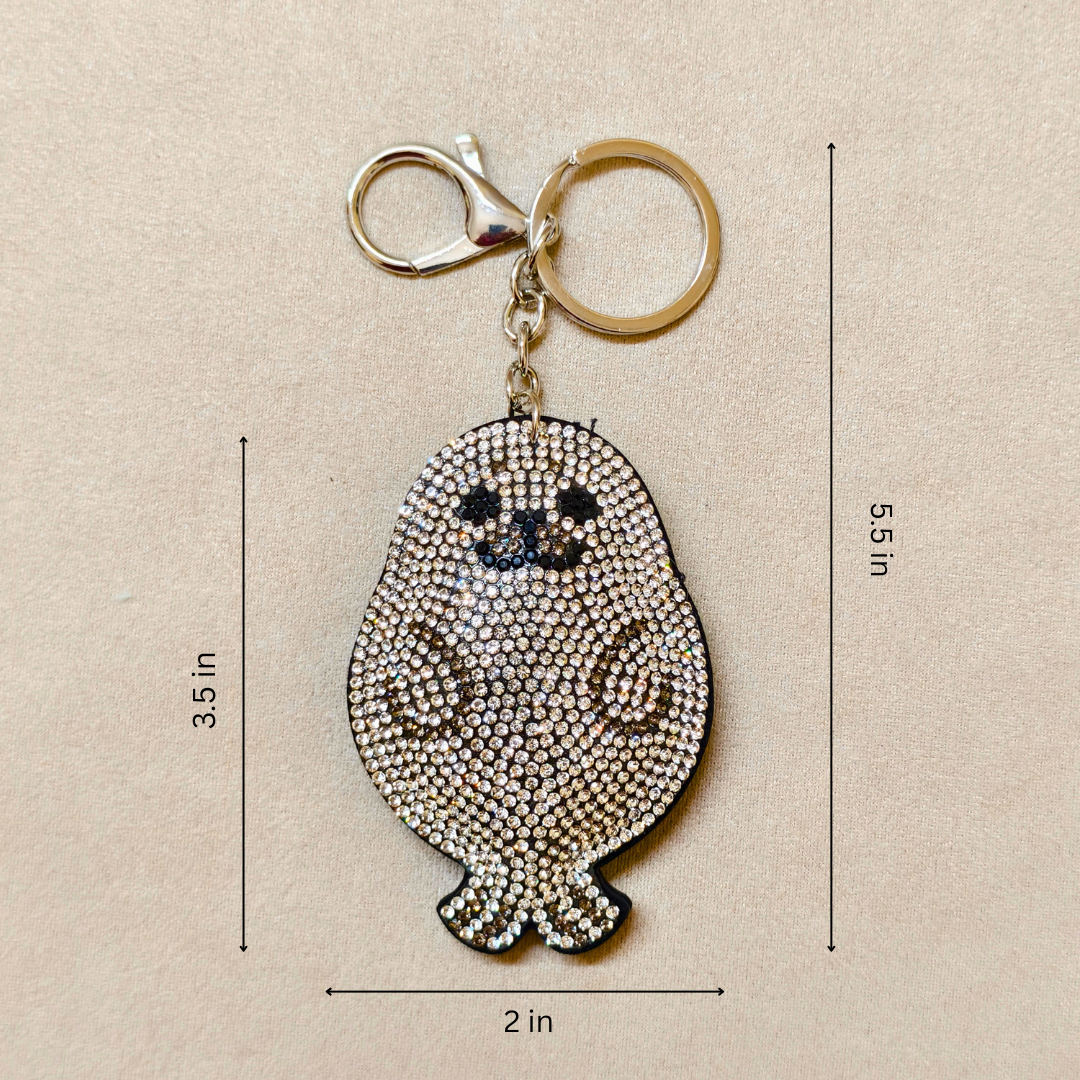 Keychain with rhinestone design of a small creature, shown with measurements on a beige background