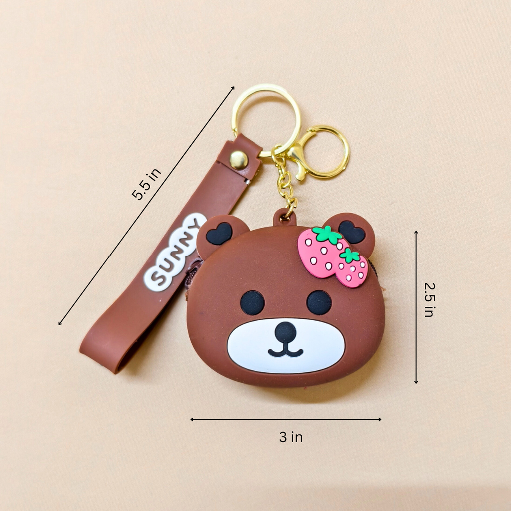 Brown bear-shaped keychain with strawberry detail and measurement lines on a beige background