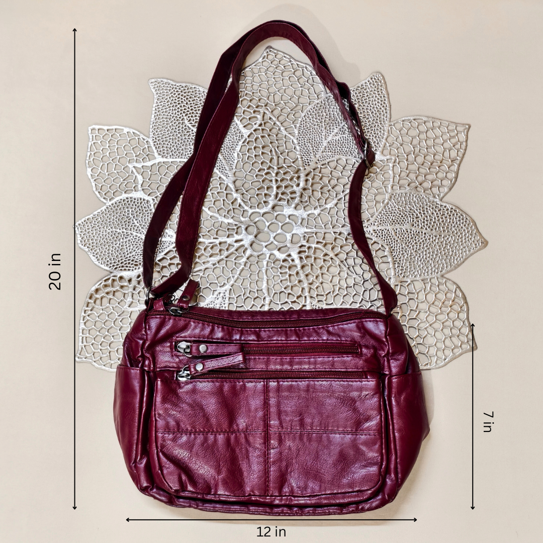 Maroon handbag with measurements on a textured beige background