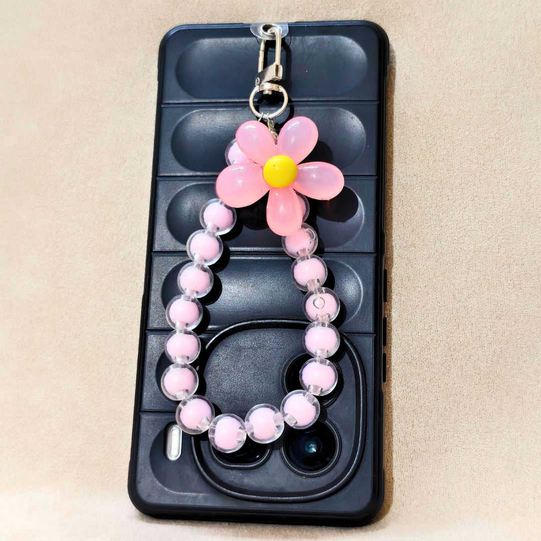 Phone case with a pink flower charm on a beige background