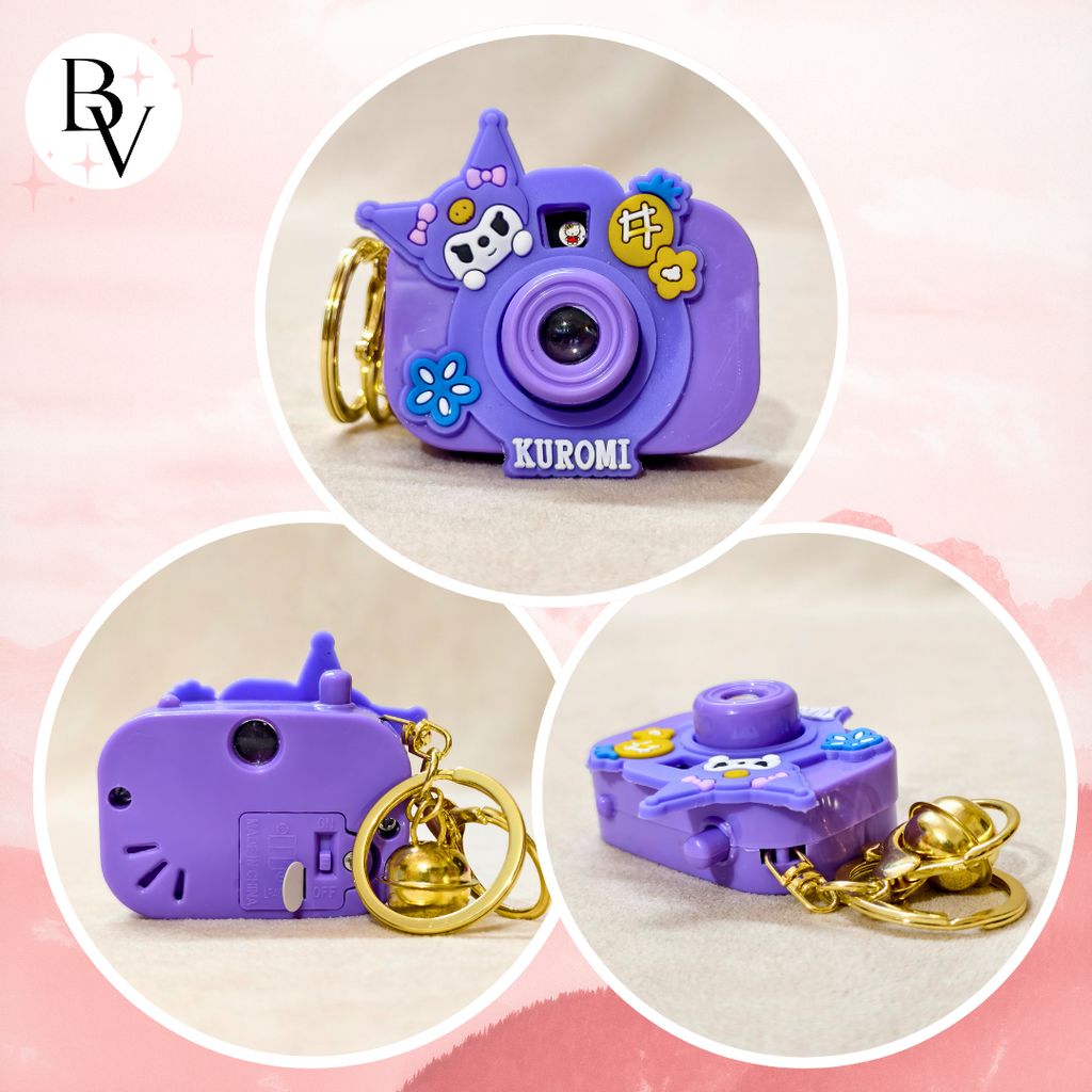 Purple Kuromi camera-shaped keychain with decorative elements on a pink background