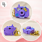 Purple Kuromi camera-shaped keychain with decorative elements on a pink background