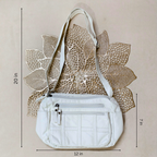 White handbag with measurements on a beige background