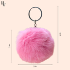 Pink fluffy keychain with measurements on a beige background