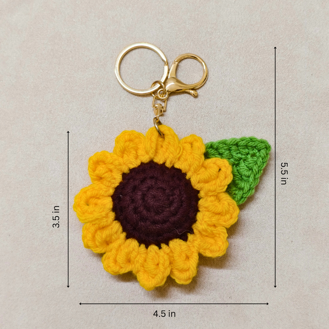 Crocheted sunflower keychain with dimensions on a beige background