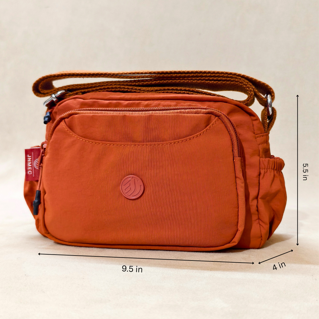 Rust Brown Sling Bag With Measurements In Front Of Beige Background.