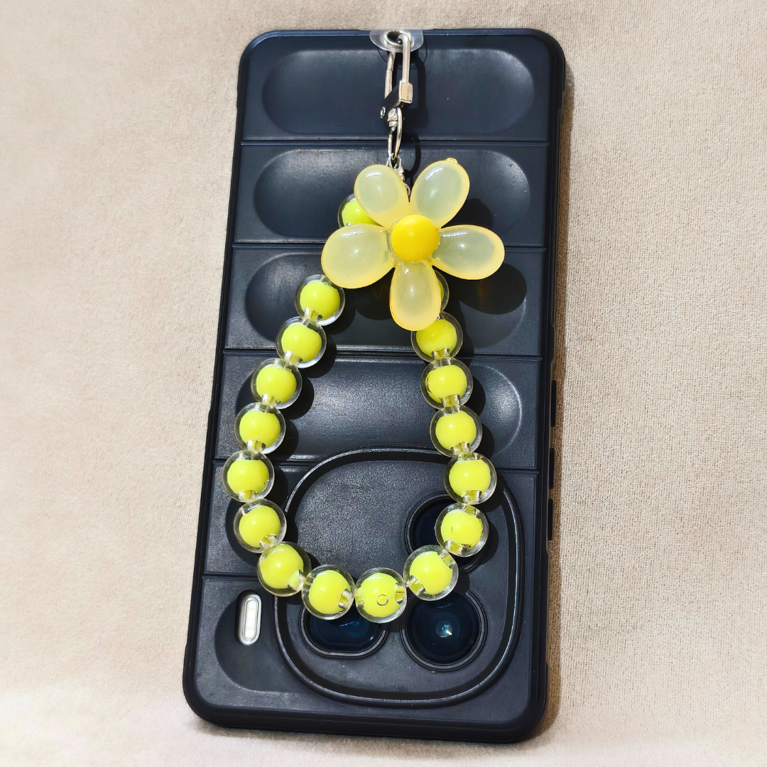 Phone case with a yellow flower charm on a beige background