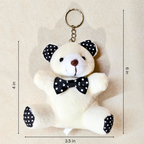 A plush teddy bear keychain with black and white polka dot ears, nose, and bow tie, shown on a beige background with dimension lines indicating 3.5 inches wide, 6 inches tall, and 4 inches from the top of the key ring.