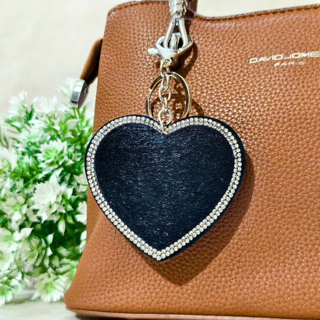 Heart-shaped keychain with rhinestones on a brown handbag with 'David Jones' branding.