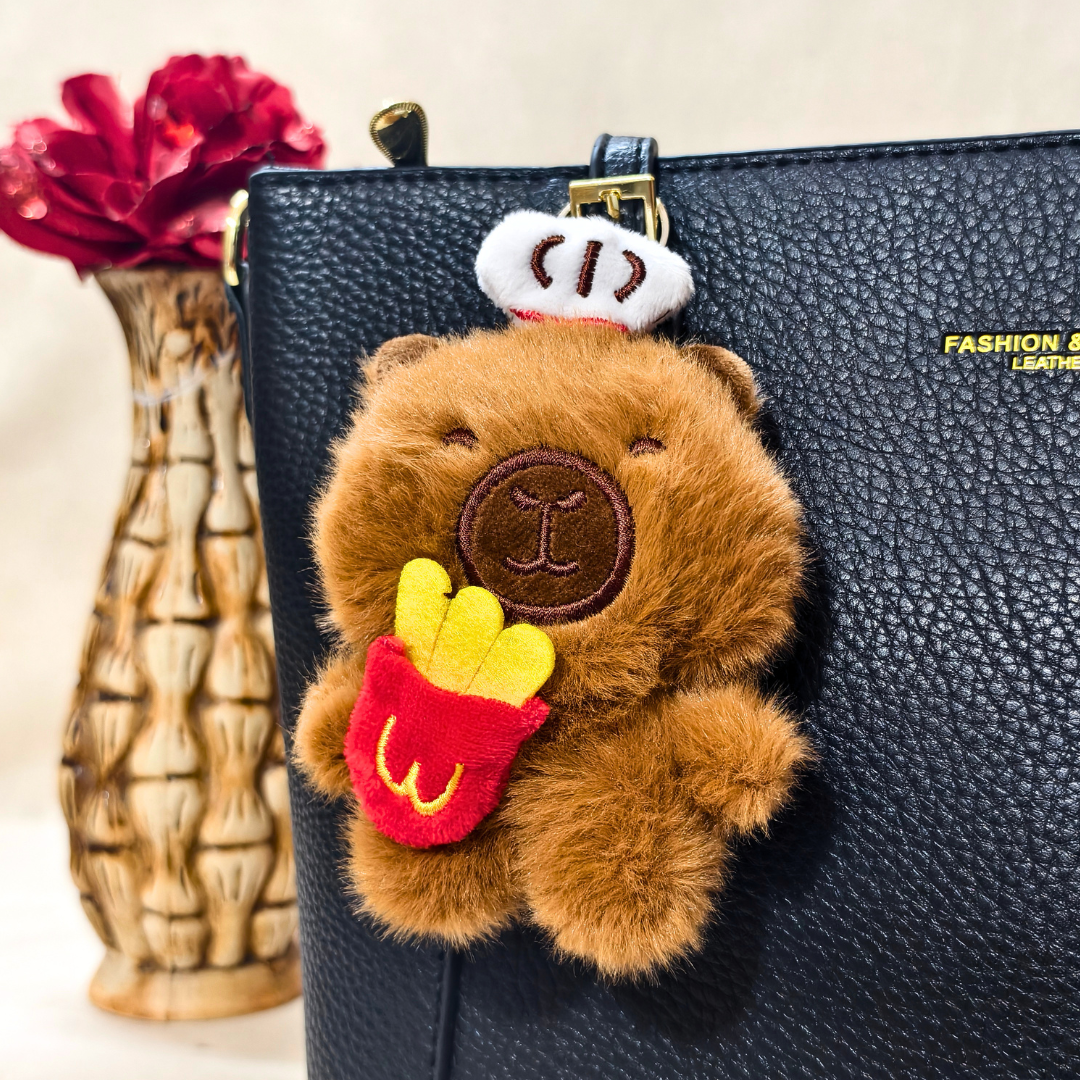 Fluffy bear keychain attached to a black leather bag with a vase in the background