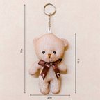 Teddy bear keychain with dimensions on a beige background