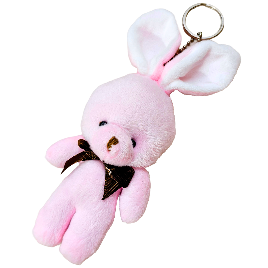 A pink plush bunny keychain with long floppy ears, a small gold-tone metal key ring, and a dark brown ribbon bow around its neck, shown on a plain white background.