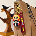 Keychain with character design attached to a brown leather bag