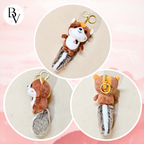 Plush squirrel keychain with a gold ring on a pink background