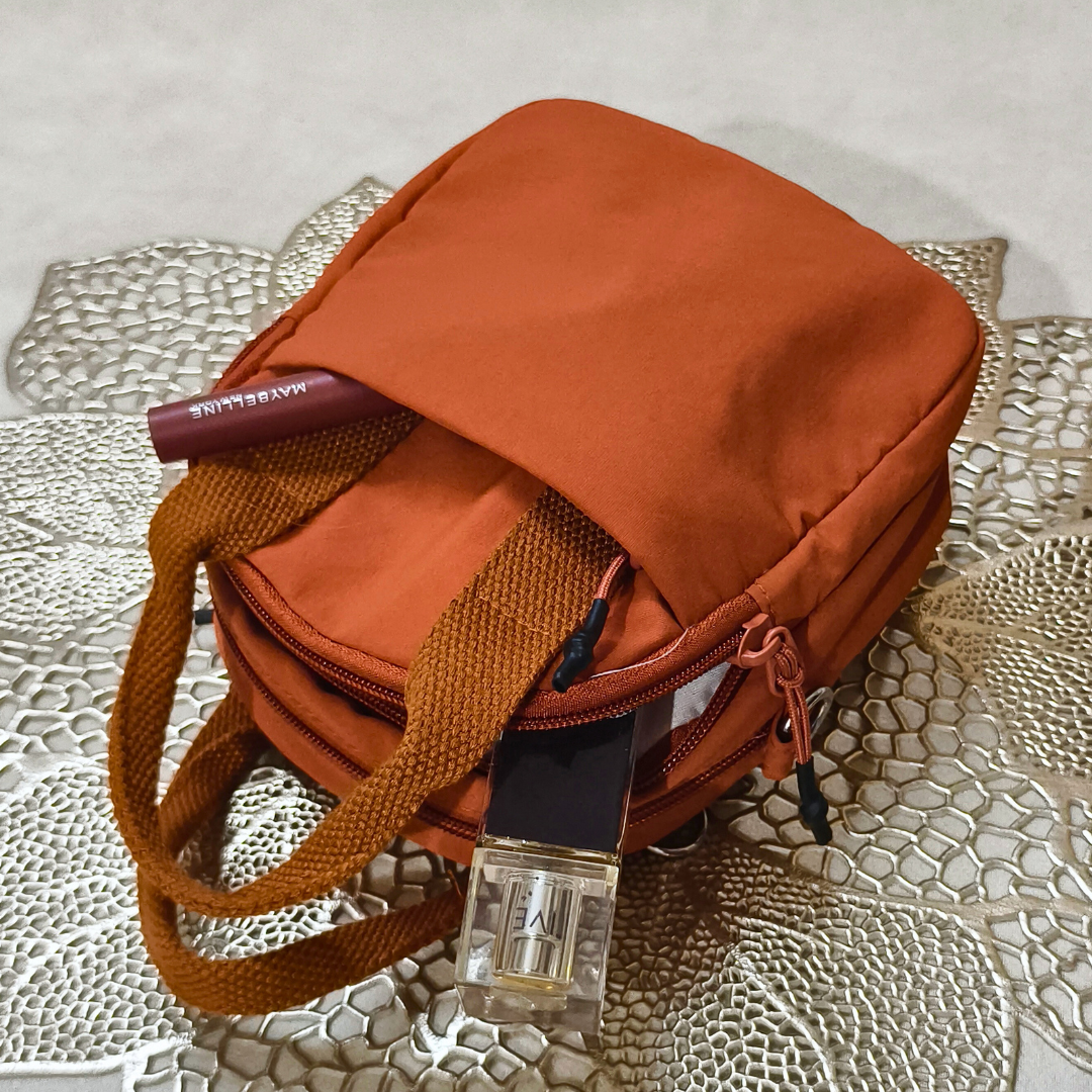 Orange bag with a strap on a textured surface