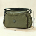 Military Green Sling Bag With Measurements In Front Of Beige Background.